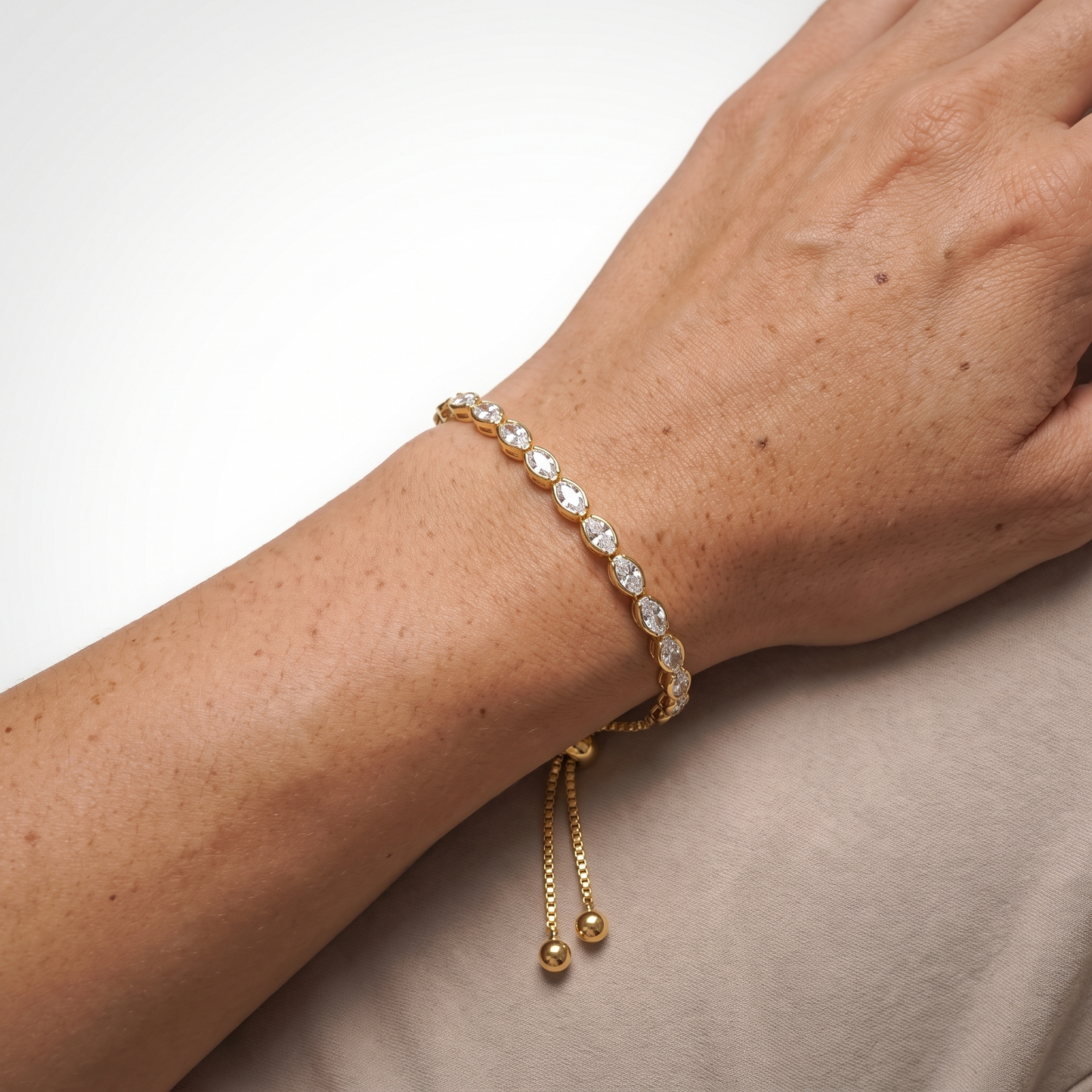 Sunoire women s tennis bracelet 4 mm 5 mm crystal cz iced cubic zirconia square tennis chain fashionable gold plated featuring pearls 02 model wearing gold oval