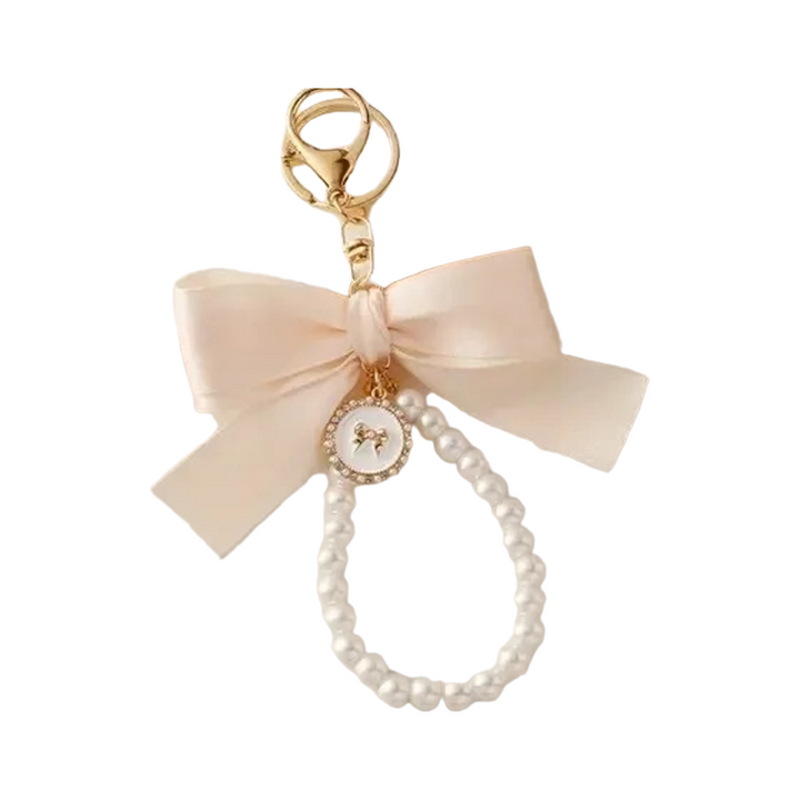 Cream ribbon bow bag charm with a faux pearl loop and gold clasp